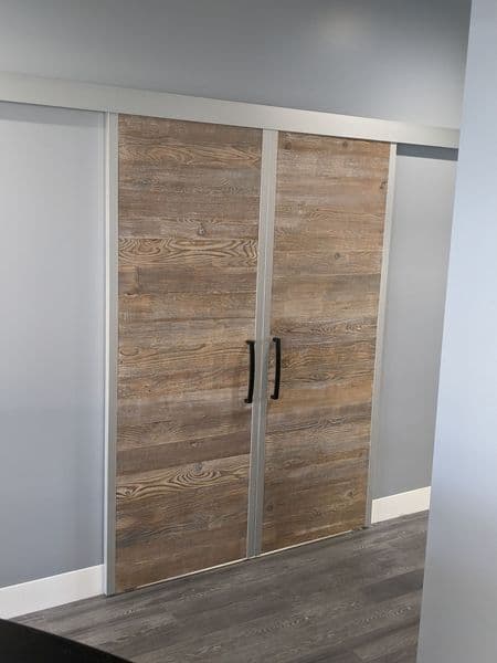 Sliding barn door with wooden panels and sleek metal frame in modern interior setting.